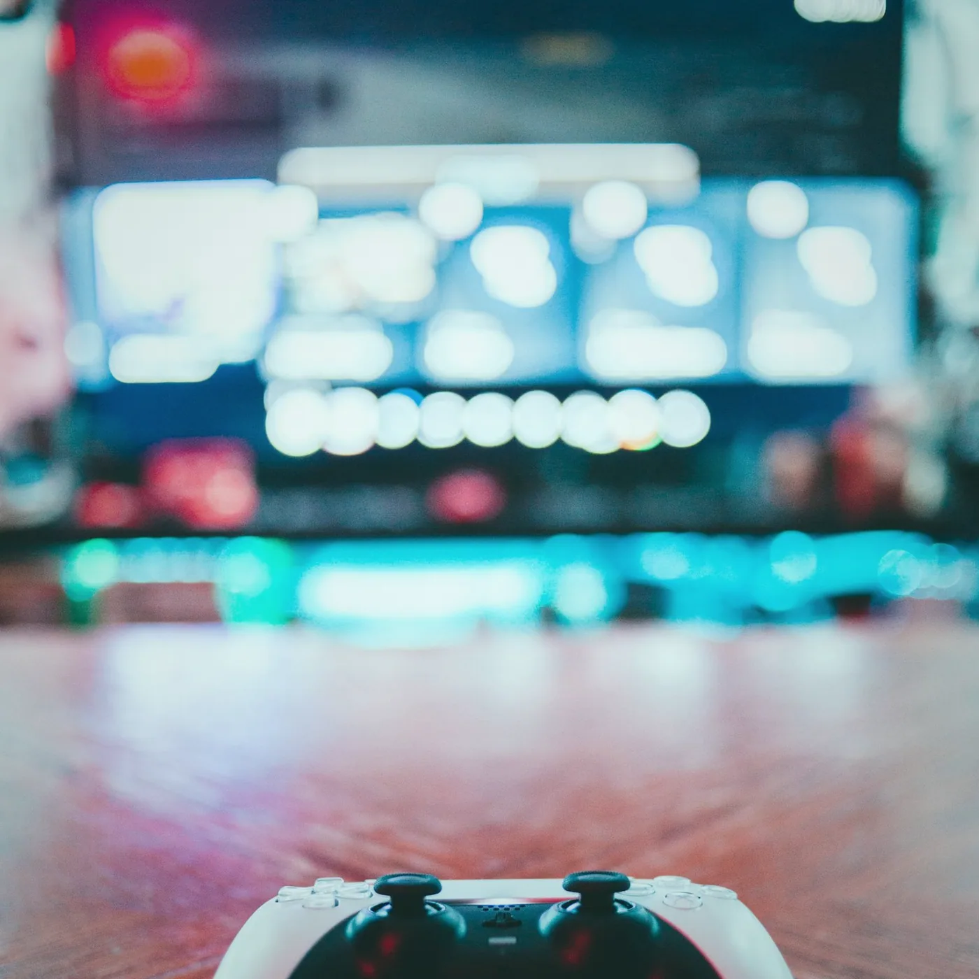 A headset resting on a keyboard beside a mouse and a mug of tea